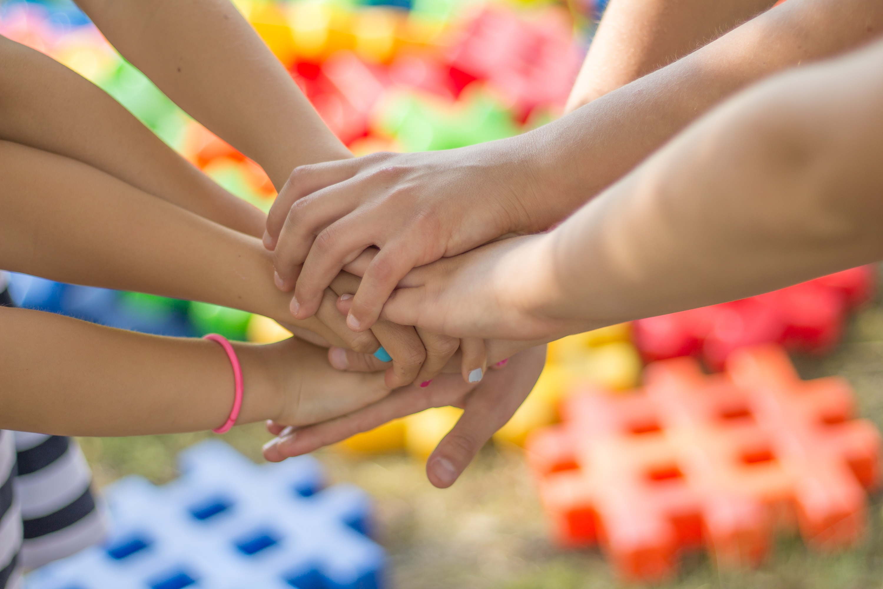 Children putting their hands together in the centre of a circle